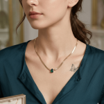 Elegant Gold Herringbone Necklace with Teardrop Emerald and White Pendant